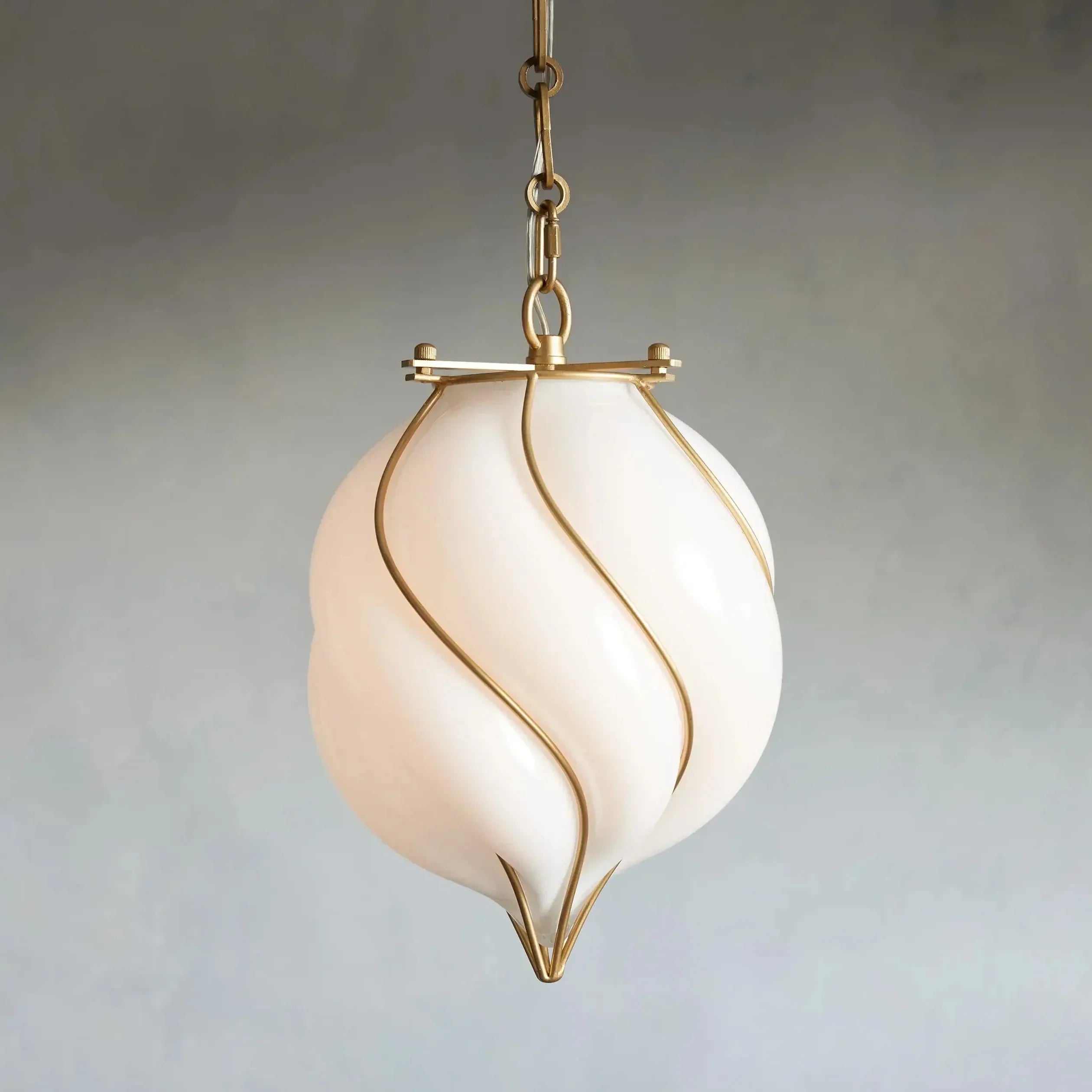 Decorative pendant light with a white glass shade and gold accents on a plain background